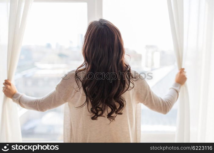 people and hope concept - close up of happy woman opening window curtains. close up of woman opening window curtains