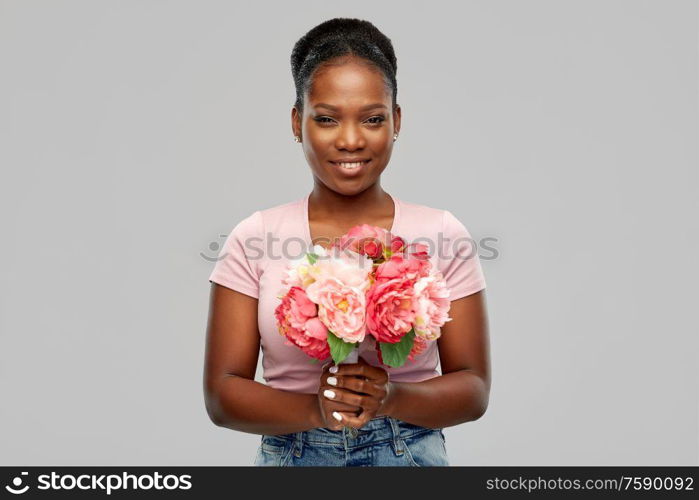 people and international women&rsquo;s day concept - happy african american young woman with bunch of peony flowers over grey background. happy african american woman with bunch of flowers