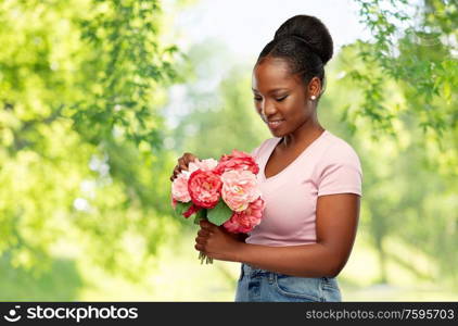 people and international women&rsquo;s day concept - happy african american young woman with bunch of peony flowers over green natural background. happy african american woman with bunch of flowers