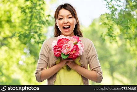 people and international women&rsquo;s day concept - happy laughing asian young woman with bunch of peony flowers over green natural background. happy laughing asian woman with bunch of flowers