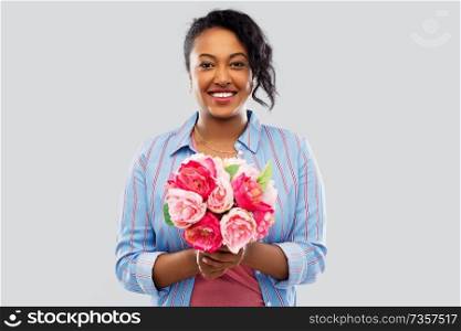 people and international women’s day concept - happy african american young woman with bunch of peony flowers over grey background. happy african american woman with bunch of flowers