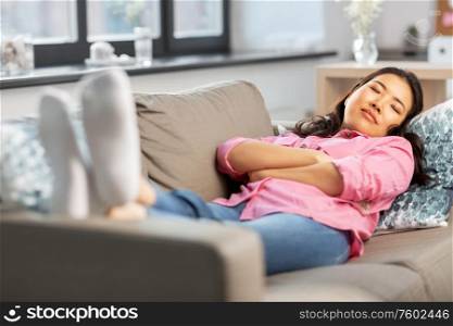 people and leisure concept - asian young woman in pink shirt sleeping on sofa and dreaming at home. young asian woman sleeping on sofa at home