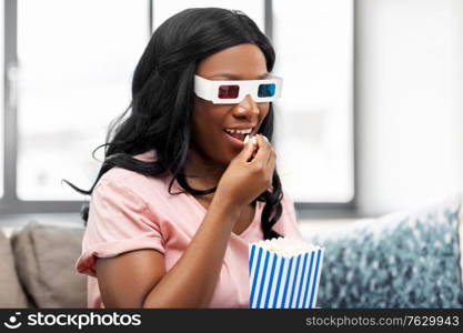 people and leisure concept - happy smiling african american young woman in 3d glasses watching tv and eating popcorn at home. happy african american woman watching tv at home