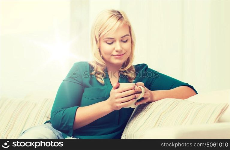 people and leisure concept - happy young woman with cup of tea or coffee at home. happy woman with cup of tea or coffee at home