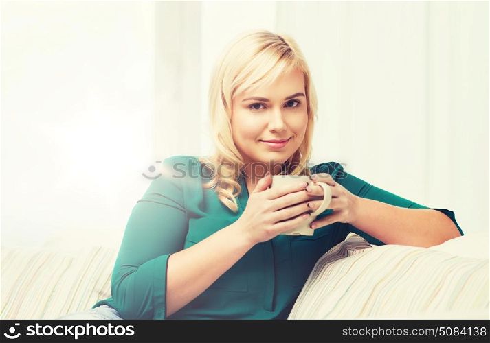 people and leisure concept - happy young woman with cup of tea or coffee at home. happy woman with cup of tea or coffee at home. happy woman with cup of tea or coffee at home
