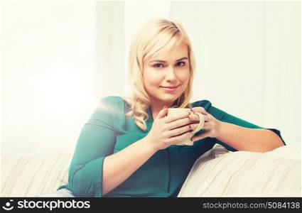 people and leisure concept - happy young woman with cup of tea or coffee at home. happy woman with cup of tea or coffee at home. happy woman with cup of tea or coffee at home