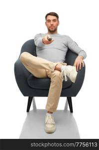 people and leisure concept - man with tv remote control sitting in chair over white background. man with tv remote control sitting in chair