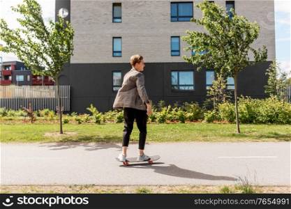 people and leisure concept - young man or teenage boy riding skateboard on city street. teenage boy on skateboard on city street