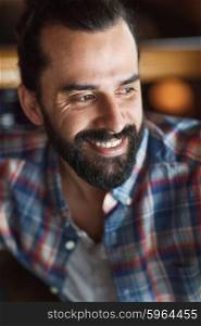 people and men concept - happy young man with beard and mustache in checkered shirt. happy young man with beard and mustache