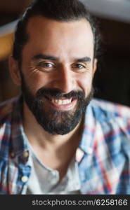 people and men concept - happy young man with beard and mustache in checkered shirt. happy young man with beard and mustache