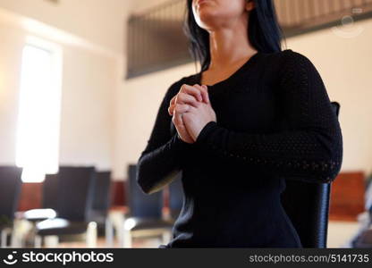 people and mourning concept - close up of unhappy woman praying god at funeral in church. close up of sad woman praying god in church