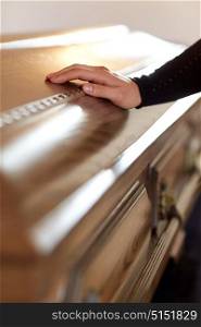 people and mourning concept - woman hand on coffin lid at funeral in church. woman hand on coffin lid at funeral in church