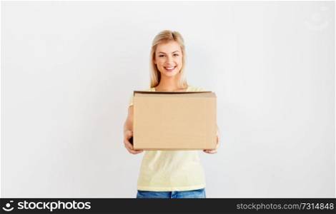 people and moving to new place concept - happy woman holding cardboard box. happy woman holding cardboard box