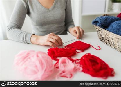 people and needlework concept - woman hands holding knitting needles and basket with yarn on table at home. woman hands with knitting needles and yarn