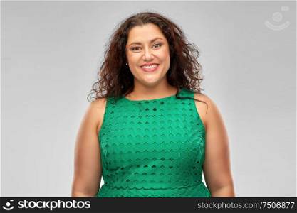 people and portrait concept - happy woman in green dress over grey background. happy woman in green dress over grey background