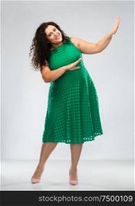 people and portrait concept - happy woman in green dress posing over grey background. happy woman in green dress over posing