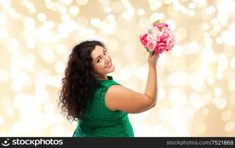 people and portrait concept - happy woman in green dress with flower bunch over festive lights background. happy woman in green dress with flower bunch