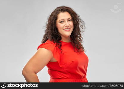 people and portrait concept - happy woman in red dress over grey background. happy woman in red dress over grey background