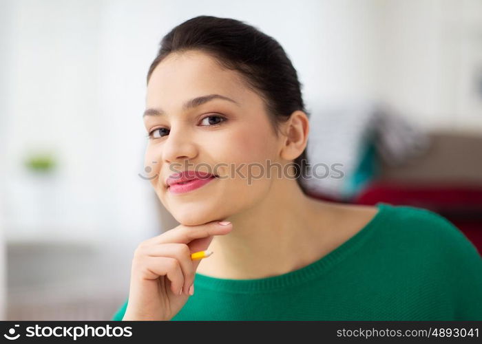 people and portrait concept - happy young woman with pencil thinking. happy young woman with pencil thinking