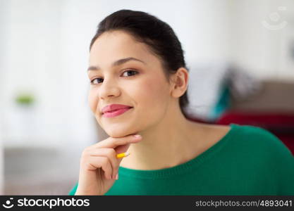 people and portrait concept - happy young woman with pencil thinking. happy young woman with pencil thinking