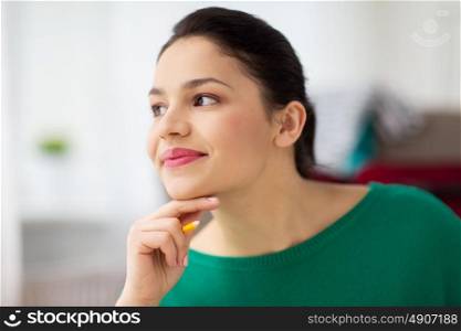 people and portrait concept - happy young woman with pencil thinking. happy young woman with pencil thinking