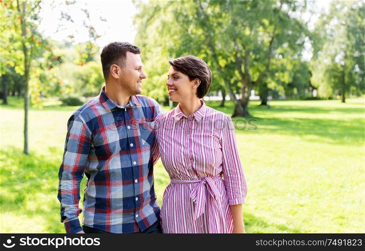 people and relationships concept - happy couple in summer park. happy couple in summer park
