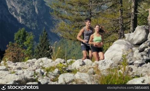 People and sport activity, young man and woman running on mountain trail. Slow motion. Part 1 of 4