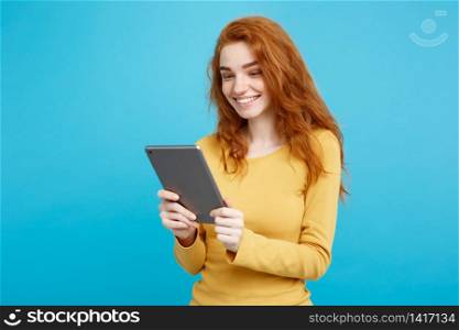 People and Technology Concept - Close up Portrait young beautiful attractive redhair girl happy smiling on digital table with wining something. Blue Pastel Background. Copy space.. People and Technology Concept - Close up Portrait young beautiful attractive tender ginger redhair girl happy smiling on digital table with wining something. Blue Pastel Background. Copy space.