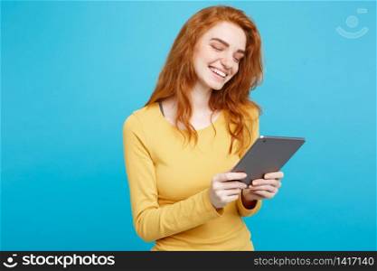 People and Technology Concept - Close up Portrait young beautiful attractive redhair girl happy smiling on digital table with wining something. Blue Pastel Background. Copy space.. People and Technology Concept - Close up Portrait young beautiful attractive tender ginger redhair girl happy smiling on digital table with wining something. Blue Pastel Background. Copy space.
