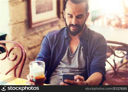 people and technology concept - man with smartphone drinking beer and reading message at bar or pub. man with smartphone drinking beer at bar or pub. man with smartphone drinking beer at bar or pub