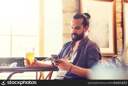 people and technology concept - man with smartphone drinking beer and reading message at bar or pub. man with smartphone drinking beer at bar or pub. man with smartphone drinking beer at bar or pub