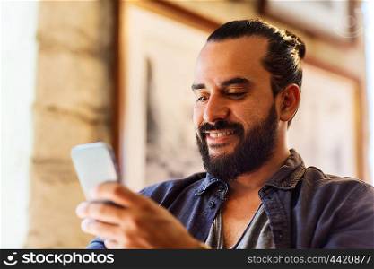 people and technology concept - man with smartphone texting message at bar or pub. man with smartphone at bar or pub