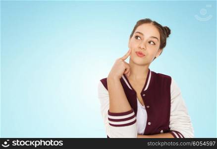 people and teens concept - happy pretty teenage girl thinking over blue background. happy pretty teenage girl thinking
