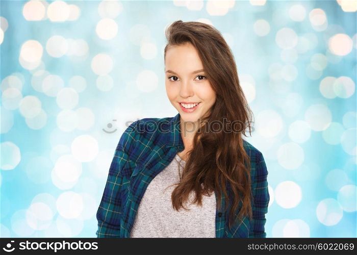 people and teens concept - happy smiling pretty teenage girl over blue holidays lights background. happy smiling pretty teenage girl