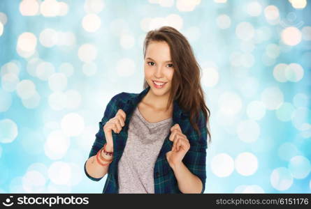 people and teens concept - happy smiling pretty teenage girl over blue holidays lights background. happy smiling pretty teenage girl