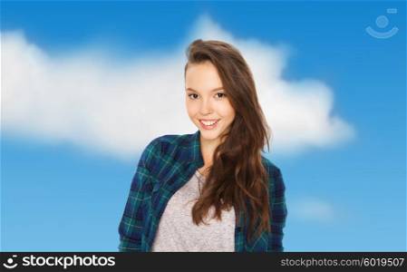 people and teens concept - happy smiling pretty teenage girl over blue sky and clouds background. happy smiling pretty teenage girl