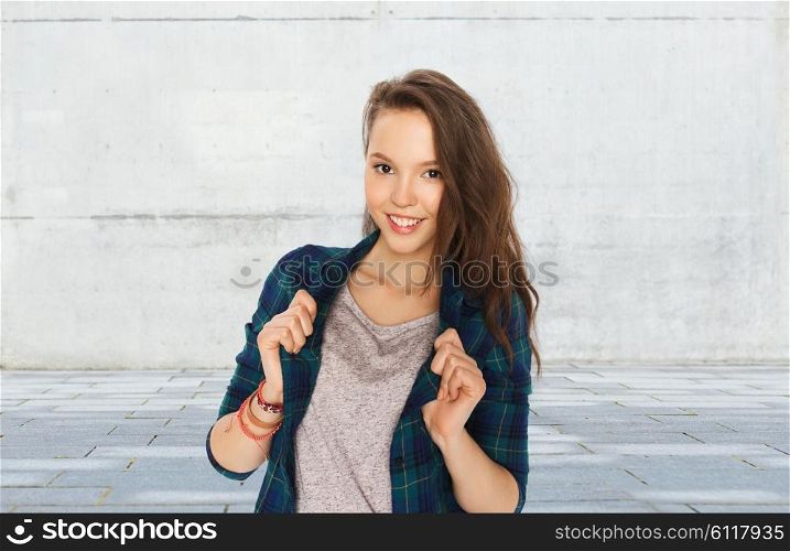 people and teens concept - happy smiling pretty teenage girl over gray urban street background. happy smiling pretty teenage girl