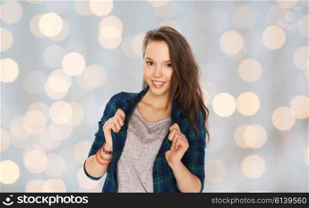 people and teens concept - happy smiling pretty teenage girl over holidays lights background. happy smiling pretty teenage girl