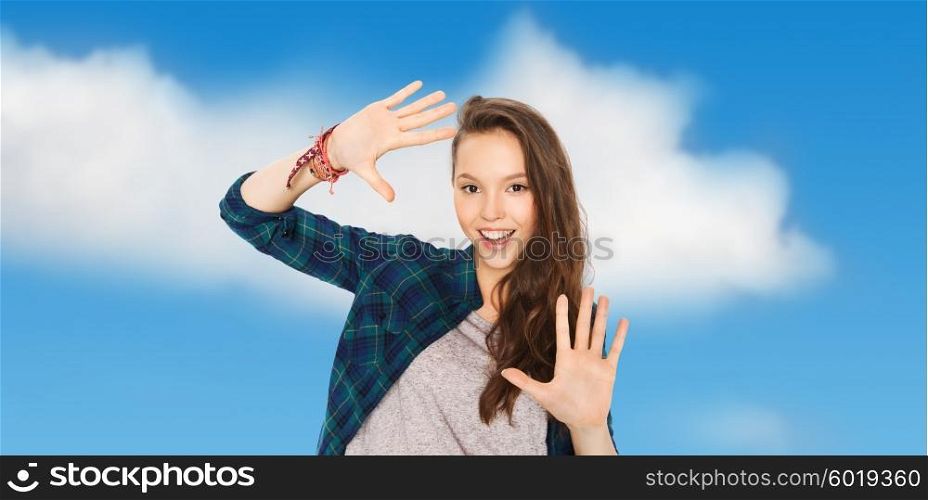 people and teens concept - happy smiling pretty teenage girl showing hands over blue sky and clouds background. happy smiling pretty teenage girl showing hands