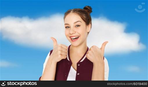 people and teens concept - happy smiling pretty teenage girl showing thumbs up over blue sky and clouds background. happy smiling teenage girl showing thumbs up