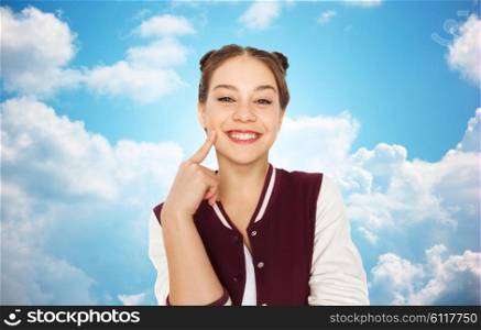 people and teens concept - happy smiling pretty teenage girl with eye makeup over blue sky and clouds background. happy smiling pretty teenage girl