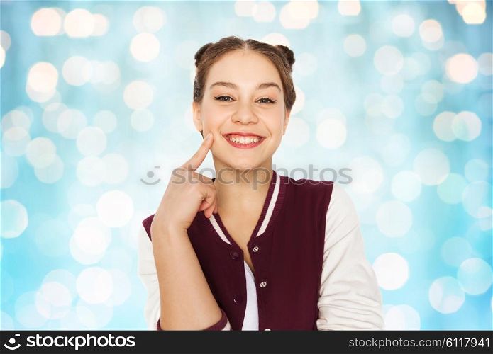 people and teens concept - happy smiling pretty teenage girl with eye makeup over blue holidays lights background. happy smiling pretty teenage girl