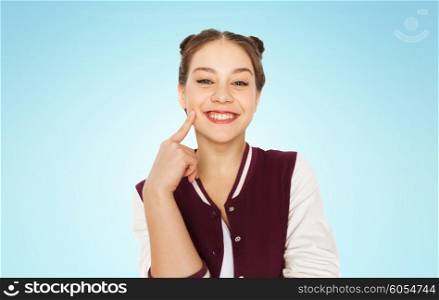 people and teens concept - happy smiling pretty teenage girl with eye makeup over blue background. happy smiling pretty teenage girl
