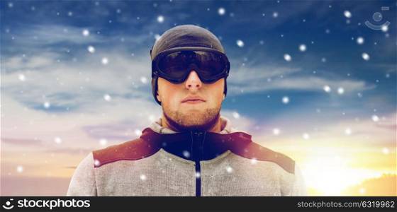 people and winter sport concept - young man in ski goggles outdoors. sports man with ski goggles in winter outdoors