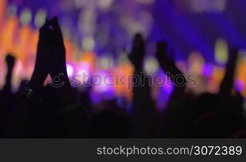 People are applauding during the performance of a musical band.