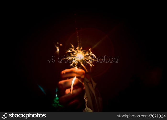 People are holding fireworks in celebrations.