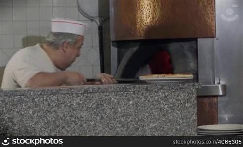 People at work, man working, food preparation, job, profession. Portrait of happy professional cook smiling, skilled chef cooking pizza in wood oven in Italian restaurant kitchen. 10 of 14