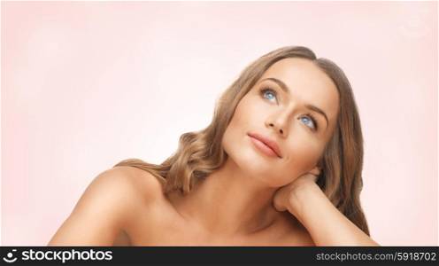 people, beauty and hair care concept - beautiful woman face with long blond hair r looking up and dreaming over pink background