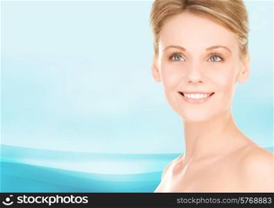 people, beauty and health care concept - close up of smiling young woman over blue background