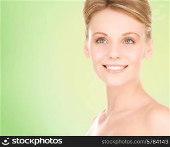 people, beauty and health care concept - close up of smiling young woman over green background